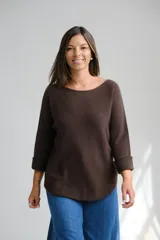 Sweater de punto color marrón chocolate, con escote redondo a la base y mangas tres cuartos con puños vueltos. Presenta un corte holgado con ruedo redondeado.