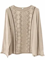 Blusa color beige con mangas largas y puños con volados. Presenta un panel frontal con bordado inglés y detalles de encaje en los laterales del pecho.