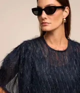 Blusa de chiffon azul marino con cuello redondo, mangas cortas con pliegues en los hombros y textura con felpas.