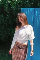 Top de viscosa color blanco, con diseño asimétrico de un hombro descubierto y manga larga holgada.