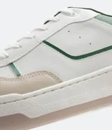 Championes urbanos de caña baja color blanco con recortes en contraste color beige y verde. Cierre con cordones y suela bicolor.