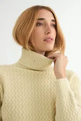 Polera de tejido de punto con cuello alto y textura acanalada en zigzag. Presenta mangas largas y puños ajustados, con un diseño clásico y versátil.
