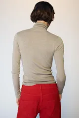 Jersey de punto con lana, color celeste, de cuello subido y manga larga, con diseño ajustado al cuerpo.
