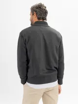 Campera tejida de punto en color azul, con cierre frontal completo y cuello alto acanalado.