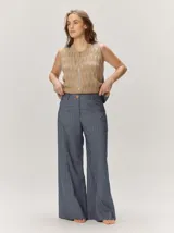 Pantalón de corte ancho y relajado, confeccionado en mezcla de algodón y lino, con diseño de rayas sutiles y cierre frontal de botón y cremallera.