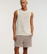 Bermuda masculina tipo runner de terciopelo cotelé, color beige, con cintura elástica, cordón ajustable y bolsillos laterales.