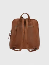 Mochila de ecocuero color caramelo con diseño de líneas limpias. Cuenta con un compartimento principal con cierre, un bolsillo frontal con cierre y detalle de borla decorativa de cuero natural. Incluye correas ajustables y logo de la marca en la parte inferior frontal.