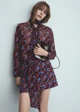 Camisa de manga larga con estampado abstracto en tonos borgoña y celeste. Tiene cuello redondo con lazo y cierre frontal con botones.