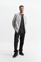 Camisa de manga larga color gris claro, con fit slim, cartera abotonada y bolsillos en el pecho.