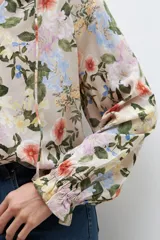 Blusa de manga larga con estampado floral multicolor y escote en V con lazo.