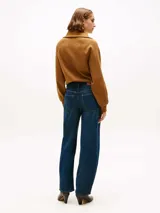 Jean de corte amplio y estilo barril con talle medio. Presenta un diseño de cinco bolsillos, cierre de cremallera con botón y un acabado con efecto desgastado en caderas y rodillas.