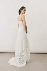 Vestido largo de encaje blanco con tirantes finos y silueta ajustada.
