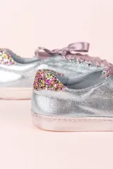 Championes celestes con glitter multicolor en punta y talón, lazo de raso y suela de cuero.