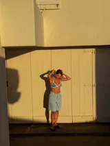 Bikini de dos piezas color beige claro con ribetes en tono rosado. El corpiño es de estilo triángulo fijo con tirantes finos y el calzón es regulable en los laterales.