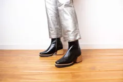 Botín de cuero negro con cierre lateral, punta cuadrada y taco de madera.