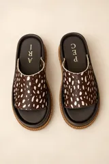 Sandalias de cuero vacuno con plataforma baja, capellada ancha de pelo con estampado animal print tipo dálmata en tonos marrón oscuro y blanco, y plantilla marrón.