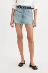 Minifalda de jean celeste con lavado claro, tiro alto, cinco bolsillos, cierre frontal con botón metálico y ruedo desflecado.