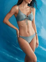 Conjunto de bikini lila con acabado brillante, compuesto por un corpiño con argolla y tiras ajustables para atar en los hombros, y una bombacha colaless con tiras laterales regulables.