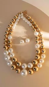 Collar de doble vuelta con cuentas combinadas de perlas blancas y esferas doradas. Incluye aros colgantes con perlas blancas.