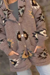 Saco tejido a mano con diseño de guardas étnicas en tonos tierra, crudo y negro. Presenta cuello solapa amplio, mangas largas con puños acanalados y cierre frontal.