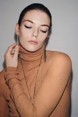 Par de aros largos plateados con apliques de strass y colgantes de cadenas finas. Cierre con tuerca.