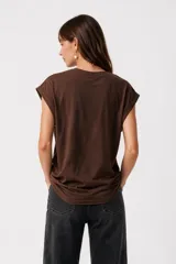 Remera negra de algodón, con cuello redondo, mangas cortas holgadas con vuelta y estampa floral grande en el pecho.