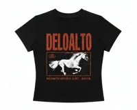 Baby tee negro ajustado de manga corta, con estampa frontal que incluye la inscripción "DELOALTO" en tono rojizo y un gráfico de un caballo blanco enmarcado con texto inferior "MONTEVIDEO EST. 2015".