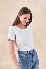 Remera de algodón de corte clásico y entallado, con cuello redondo y mangas cortas con detalle de costura decorativa en el borde.