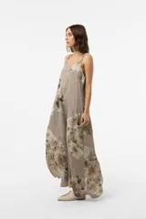 Vestido largo verde militar con estampado floral, silueta amplia y fluida, escote redondeado y breteles con detalle de botones.