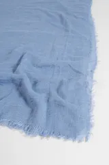Pashmina rústica de color celeste con textura arrugada y flecos en los extremos.