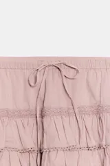 Shorts tipo pollera marrón de tiro medio, con cintura ajustable con cordones, diseño de múltiples volantes en capas y detalles de encaje a tono.
