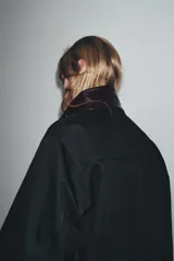 Chaqueta negra de la colección Zara Woman, confeccionada en hilatura con mezcla de algodón. Presenta un cuello alto brillante en contraste de color marrón oscuro, manga larga, bolsillos delanteros y pespuntes marcados. El forro interior es a contraste y el cierre frontal es con botones.