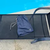Short de baño negro con cintura elástica y cordón ajustable bicolor. Presenta un parche circular con logo en la parte inferior de la pierna.