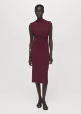 Vestido midi de color bordó, sin mangas, con cuello redondo y diseño entallado. Presenta un detalle de fruncido lateral en la cintura y cierre posterior.