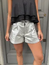 Short plateado de eco cuero metalizado elastizado, de tiro alto y corte acampanado.