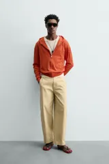 Sudadera con capucha de corte relajado, confeccionada en tejido a rayas horizontales en tonos naranja. Cuenta con cierre frontal de cremallera, cordones ajustables en la capucha y puños y ruedo en rib.