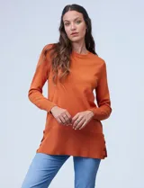 Buzo color naranja de tejido fino marca Tint & Shadow, con ruedo lateral y aplique de botones.