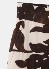 Pantalón largo de corte recto y tejido fluido, con diseño estampado floral en tonos marrón y crudo, bolsillos laterales y cierre oculto.