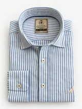 Camisa Club House de manga larga y corte clásico, confeccionada en 100% lino color azul con diseño de rayas finas verticales blancas. Presenta cuello corto, cierre frontal con botones blancos y detalle de bordado de un pájaro en el pecho.