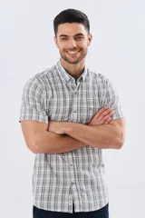 Camisa de manga corta a cuadros en tonos gris, blanco y azul, confeccionada en mezcla de lino y algodón, con cuello camisero abotonado y cierre frontal con botones.