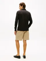 Chomba de manga larga de Tommy Hilfiger en color negro, confeccionada en mezcla de algodón y modal con tejido interlock ligero. Cuenta con cuello clásico, cartera de cuatro botones y el logo bordado en el pecho.