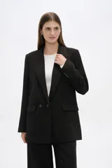 Blazer negro de corte holgado con cuello solapa, cierre frontal con botones y bolsillos laterales con solapa.