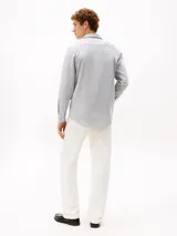 Camisa de manga larga Tommy Hilfiger de corte slim, confeccionada en tejido de piqué Oxford color azul claro. Presenta cuello inglés, cierre frontal con botones y el logo de la marca bordado en el pecho.