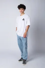 Remera negra de corte oversize confeccionada en algodón pesado, con estampa pequeña de Mickey Mouse en el pecho y diseño gráfico en la espalda.