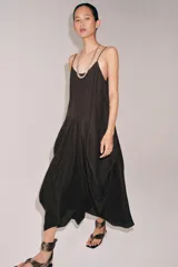 Vestido midi de tirantes finos con escote redondo, confeccionado en mezcla de viscosa y lino. Presenta un diseño con volumen, detalle de pliegues frontales y bajo asimétrico.