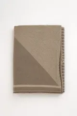 Bufanda de tejido de punto en tonos marrón y tostado, con diseño geométrico y flecos en los extremos.