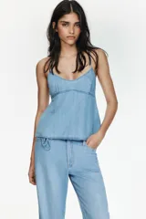 Top de denim con escote en pico, tirantes finos y diseño con lazada ajustable en la espalda.