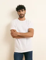 Remera básica de algodón color beige, de manga corta, con cuello redondo y un pequeño detalle bordado en el pecho.