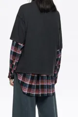 Camiseta negra de corte oversize con cuello redondo y mangas cortas. Presenta un estampado gráfico grande en el frente que simula un paisaje nocturno o crepuscular con un ciervo, árboles y montañas.