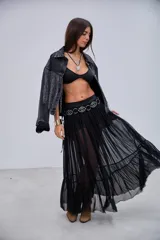 Pollera larga de microtul negro, con cintura elástica y detalles de aros metálicos y tachas.